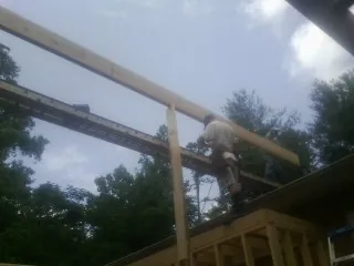 Carpenter setting a ridge beam over a new addition frame — Ice Dam Removal by Roofing Brothers in Wheaton